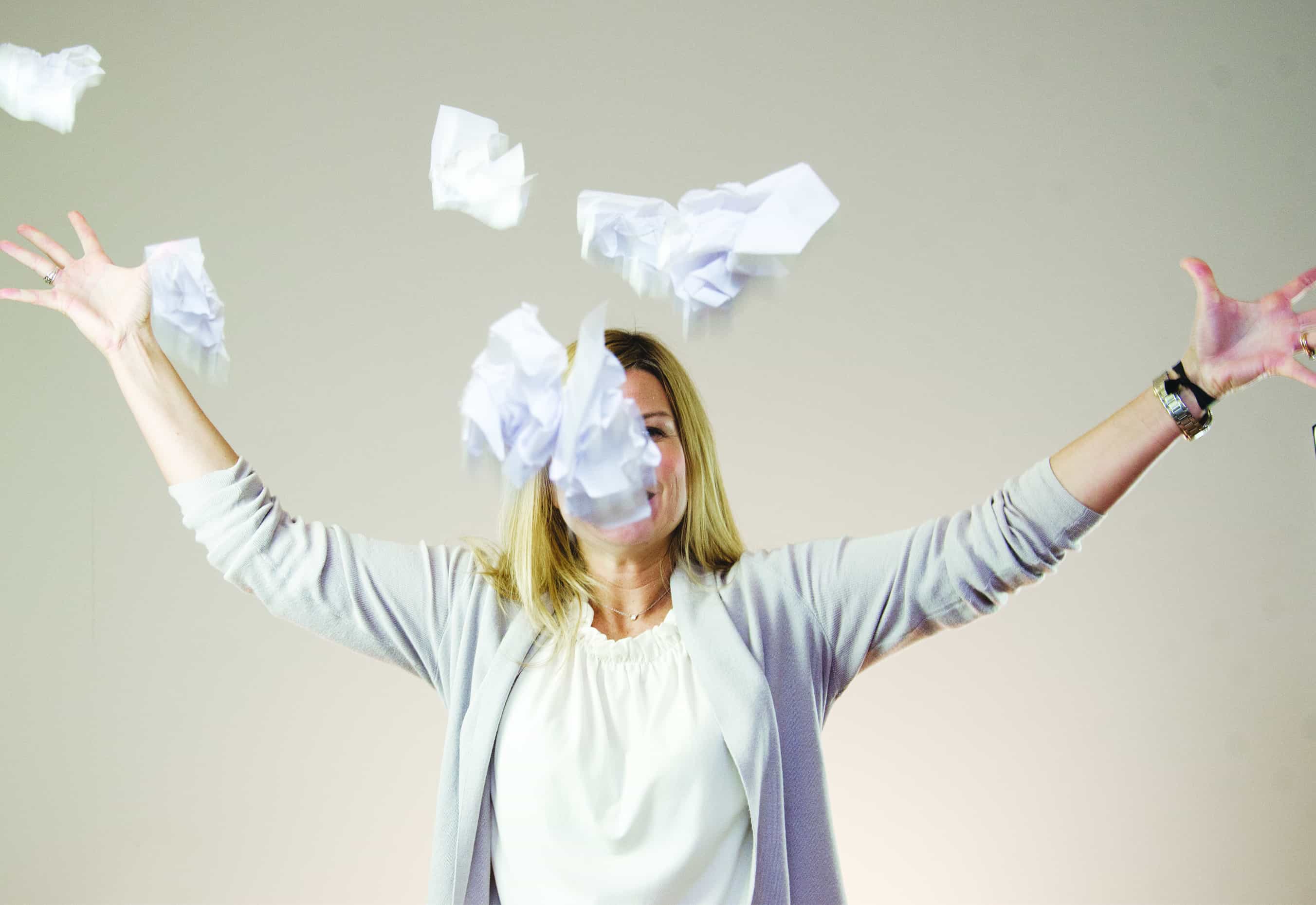 Leslie throwing papers into the air - Web Design Project Manager at Big Imprint